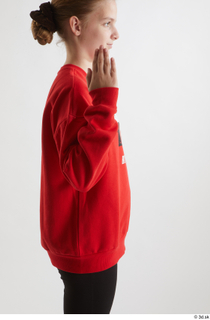 Selin  1 arm dressed flexing red hoodie side view…